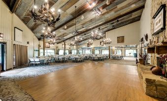 "a large , empty room with wooden floors and ceiling , decorated with chandeliers and signs reading "" wood "" on the walls" at North Texas Jellystone Park