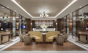 a modern hotel lobby with a wooden floor , a large reception desk , and several chairs at DoubleTree by Hilton Skopje