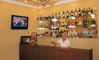 a woman standing behind a bar counter in a restaurant , holding a glass of beer at Serebryanyy Bor