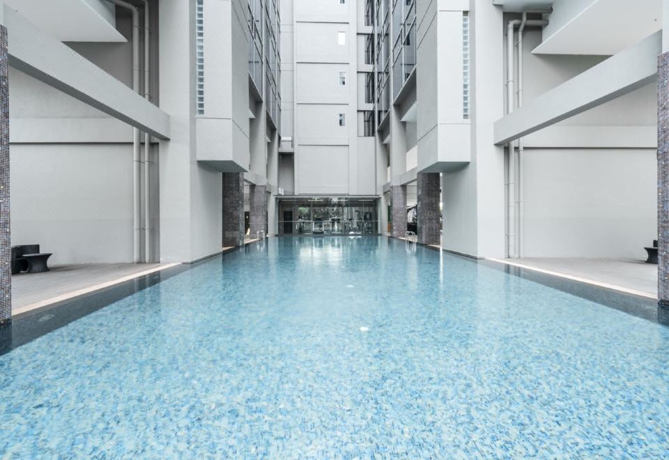 The large building or hotel features an indoor pool with blue water at V Hotel Lavender