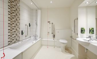 a modern bathroom with white walls , a bathtub , toilet , and shower area , along with red lines indicating the path of movement at Swindon North