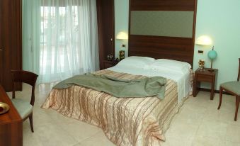 a large bed with a wooden headboard and white sheets is in a room with green walls at Hotel Royal