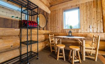 a room with wooden walls , a black shelf , and two wooden stools in front of a window at Boulder Mountain Resort