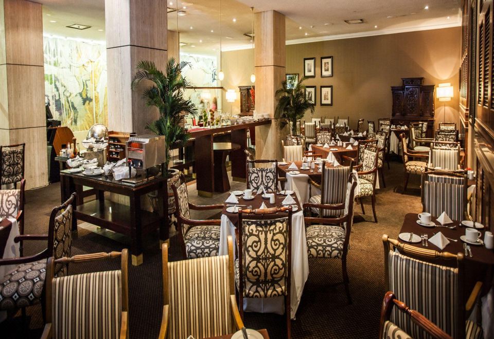a large dining room with multiple tables and chairs arranged for a group of people to enjoy a meal together at The Royal Hotel by Coastlands Hotels & Resorts