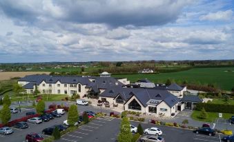 an aerial view of a large hotel complex with multiple buildings and parking lots , surrounded by a field and trees at Clanard Court Hotel