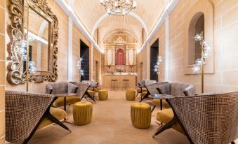 a luxurious hotel lobby with multiple seating arrangements , including couches and chairs , as well as a bar area at Hotel Creu de Tau Art&Spa-Adults Only