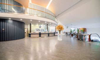 a spacious lobby with a reception desk and a large vase of flowers on a table at Duja Bodrum