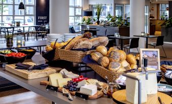 a dining table with a variety of food items , including bread , cheese , and other snacks at Pier 5 Hotel