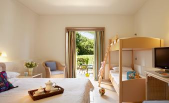 a bedroom with a bed , chair , and rocking chair is shown with an open door leading to a garden at Grecotel Meli Palace