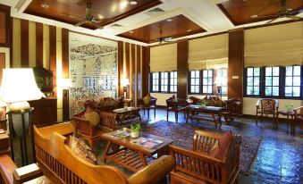 a large , well - decorated room with wooden furniture and artwork on the walls , including an intricate mural at Lavilla by Holiday Villa Cherating