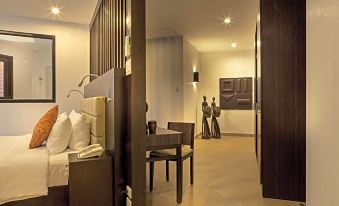 a bedroom with a bed , table , and chairs is shown in an open space with wooden accents at Busuanga Bay Lodge