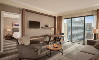 a hotel room with a comfortable couch , a television , and a window overlooking the city at Hyatt Regency Birmingham