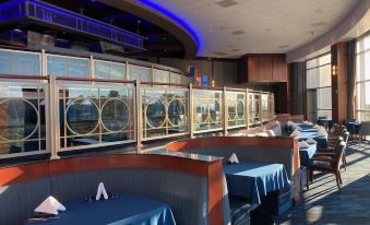 a restaurant with blue tables and chairs , a large window , and a blue awning over the bar at Gold Country Casino Resort