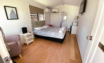 a small , well - furnished bedroom with a double bed , a television , and a bathroom next to it at Warrego Hotel Motel Cunnamulla