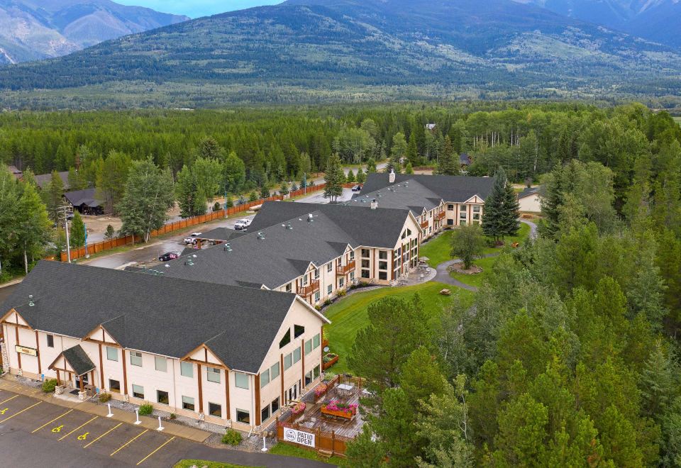 an aerial view of a hotel with multiple buildings surrounded by trees and mountains in the background at Best Western Plus Valemount Inn  Suites