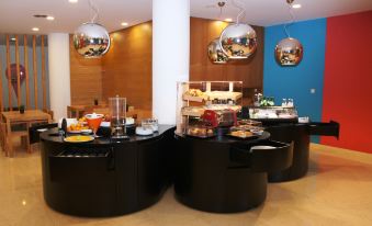 a buffet - style dining area with a variety of food items and utensils , including bowls , spoons , and forks at Stay Hotel Guimarães Centro
