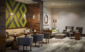 a modern lounge area with wooden walls , green geometric design , and comfortable seating arrangements for guests at Portland Marriott Downtown Waterfront