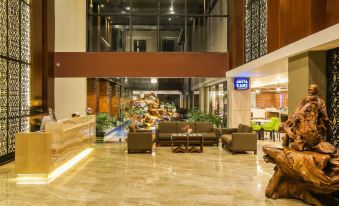 a modern hotel lobby with a large reception desk , couches , and a statue of an elephant at Swiss-Belinn Timika