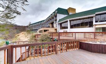 a large building with a green roof is next to a wooden deck and trees at The Chateau Resort