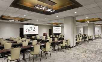 "a large conference room with rows of tables and chairs , a large screen on the wall , and the words "" hyatt centric "" displayed" at Hyatt Centric Arlington