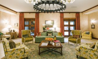 a spacious living room with multiple chairs and couches arranged in a circle around a coffee table at Hotel Viata