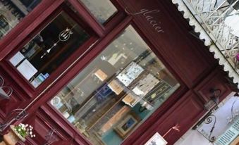 a store window with various items on display , including a clock and some other items at Le Petit Chou