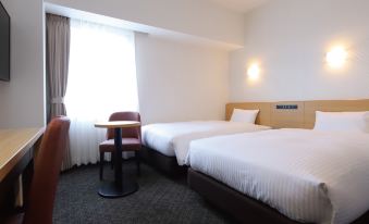 We have a bedroom with two beds and a table by the window available for daily use at AB Hotel Kisarazu