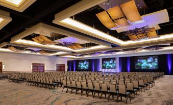 a large , empty conference room with rows of chairs and multiple screens , all illuminated by purple lights at JW Marriott San Antonio Hill Country Resort & Spa