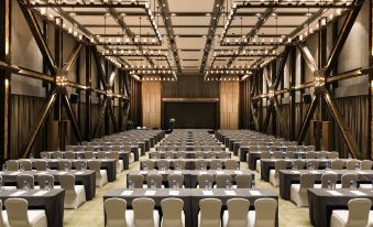 A setup for an event with rows of tables and chairs facing a podium in the middle at Novotel Shanghai Clover