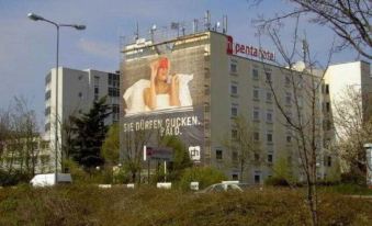 "a large building with a billboard advertising "" pepsi - cola "" and "" psilocybin ""." at Pentahotel Wiesbaden