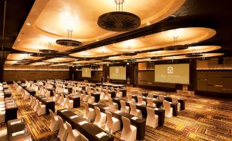 a large , empty conference room with rows of white and black chairs arranged in an orderly fashion at Pan Pacific Perth