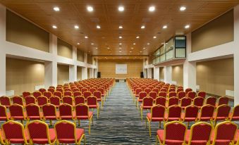 a large conference room with rows of red chairs arranged in a semicircle , creating an auditorium - like setting at Duja Bodrum