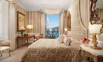 a luxurious bedroom with a large bed and a view of the ocean through a window at Hotel d'Angleterre