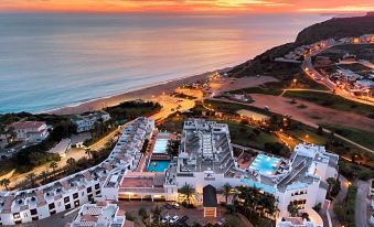 aerial view of a beach resort with multiple buildings , pools , and people enjoying the sunset at Belmar Spa & Beach Resort