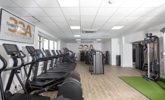 a well - equipped gym with a variety of exercise equipment , including treadmills , elliptical machines , and weight machines at Springfield Hotel and Restaurant
