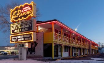 "a neon sign for "" roadhouse "" restaurant & bar is lit up on the side of a building" at Hotel El Rancho