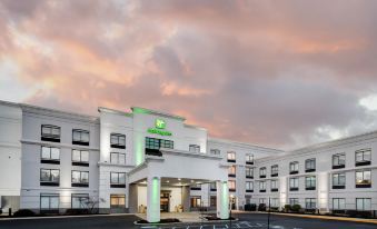 a large white building with a green and white logo , possibly a hotel or resort , located in a city setting at Holiday Inn Allentown-Bethlehem
