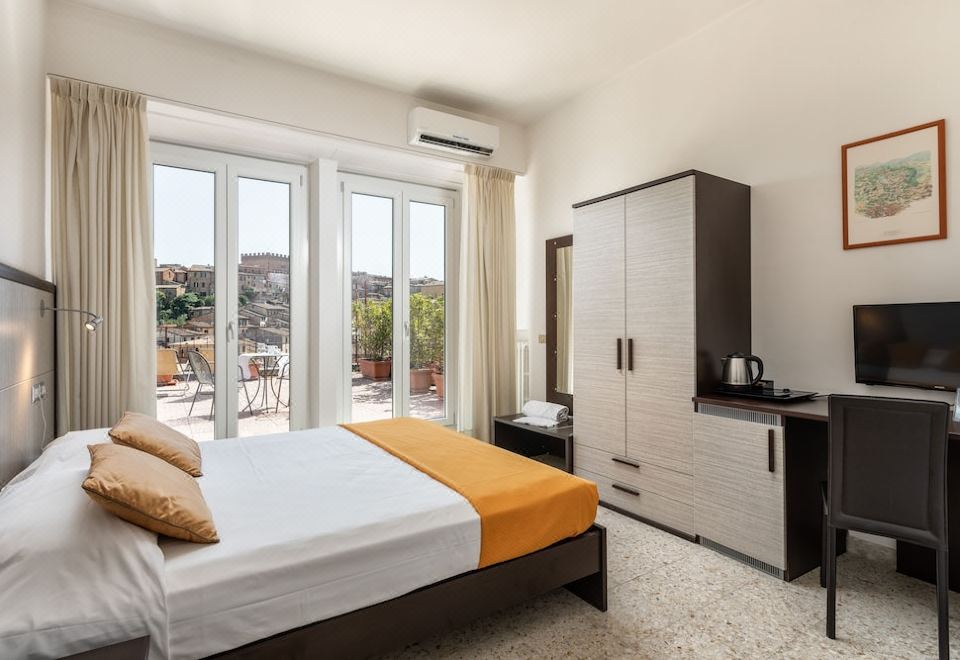 a bedroom with a large bed , white and orange bedding , and a sliding glass door leading to a balcony at Hotel Minerva