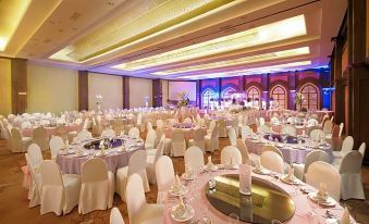 a large banquet hall is filled with white chairs and tables , all set for a formal event at MetroCentre Hotel