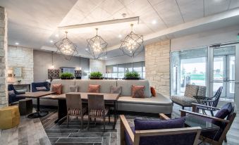 a modern living room with a couch , chairs , and dining table is shown in this image at Home2 Suites by Hilton Fort Worth  Northlake