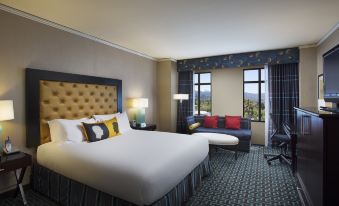 a luxurious hotel room with a large bed , white bedding , and a view of the city through a window at Juniper Hotel Cupertino, Curio Collection by Hilton