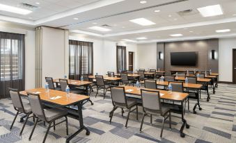 a large conference room with several rows of chairs arranged in a semicircle around a table at Hyatt Place Melbourne / Palm Bay / I-95