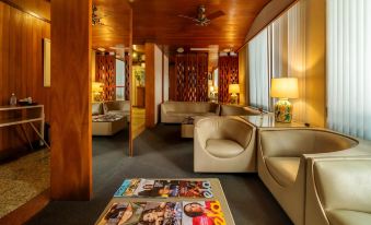 a room with wooden walls and ceiling , featuring several couches and chairs arranged in a seating area at Infinity Copacabana, Ex-APA Hotel