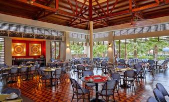 a large , well - lit dining room with numerous tables and chairs arranged for a group of people at Royal Decameron Punta SAL - All Inclusive