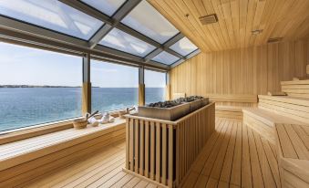 a modern sauna with large windows offering an ocean view , wooden flooring , and a stone counter at Hotel Histrion
