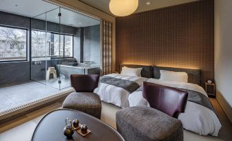 a modern hotel room with a large bed , a bathtub , and a balcony overlooking a spa at Zazan Minakami