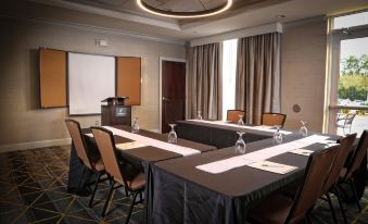a conference room set up for a meeting , with chairs arranged in a semicircle around a table at Holiday Inn Statesboro-University Area