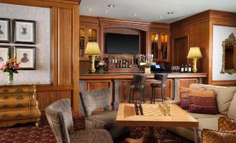a cozy living room with wooden furniture , including a couch , chairs , and a dining table at Little America Hotel & Resort Cheyenne