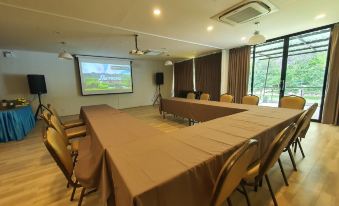 a large conference room with multiple tables and chairs arranged for a meeting or event at Phuphayot Resort