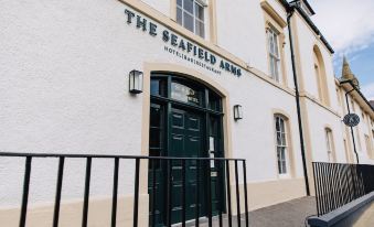 "a white building with a black door and the sign "" the seaheld arms "" in white" at The Seafield Arms-Cullen